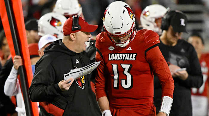 Louisville head coach Jeff Brohm gives instructions to quarterback Jack Plummer on the sideline